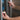Close-up of a hand holding a needle-free bottle adaptor for VetIMMUNE PI while reaching for a refrigerator.