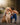 Photo of a woman in a tank top, jeans, and hiking boots kissing her golden retriever dog